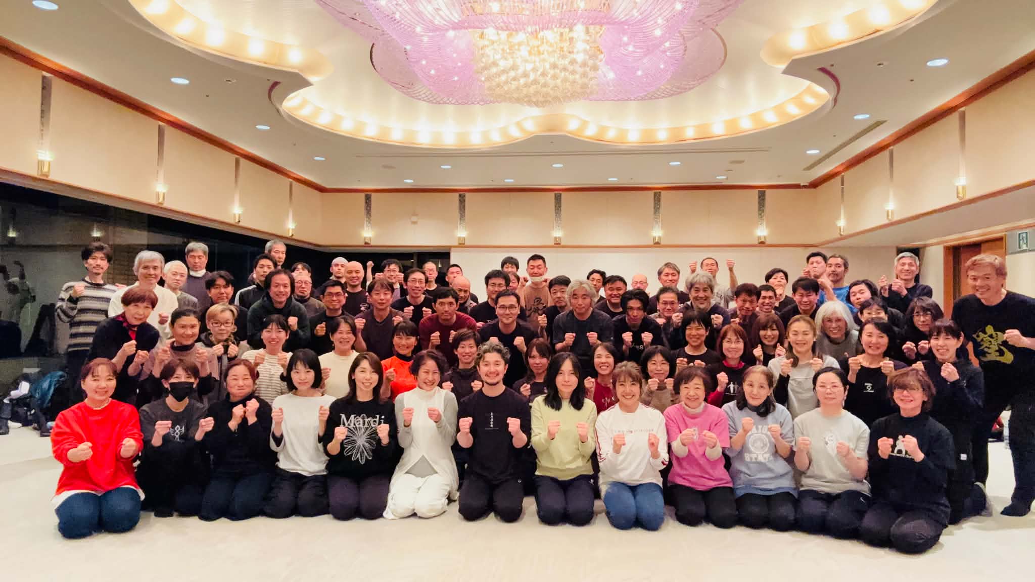 広い会場で拳を構えた、フィジカリストOuJiと皆さんの集合写真